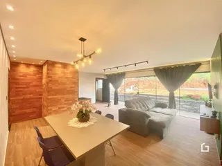 Sala de estar com parede de madeira e vista para o exterior.