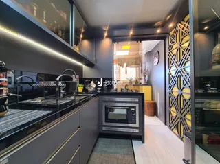 Interior de uma cozinha moderna com armários escuros e eletrodomésticos de aço inoxidável.