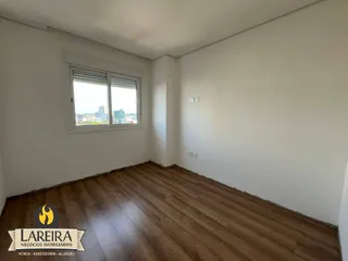 Ambiente interno com piso de madeira e paredes brancas.