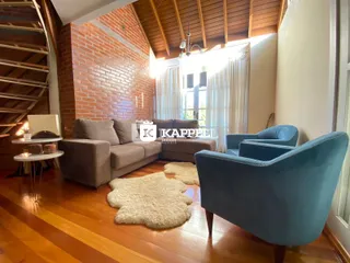 Sala de estar com sofá e poltronas azuis em ambiente com piso de madeira.