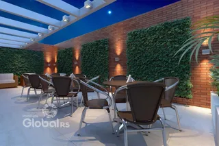 Uma área externa com mesa e cadeiras em um ambiente com parede de tijolo e vegetação.