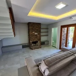 Sala de estar com lareira de tijolos e sofá.