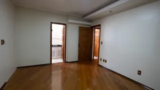 Ambiente interno com piso de madeira e porta de entrada.