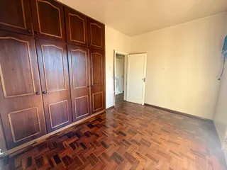 Ambiente interno com armários de madeira e piso de madeira no imóvel.