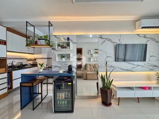 Ambiente moderno de sala de estar e cozinha em um imóvel no Brasil.