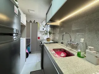 Imagem de uma cozinha moderna com armários brancos e bancada clara.