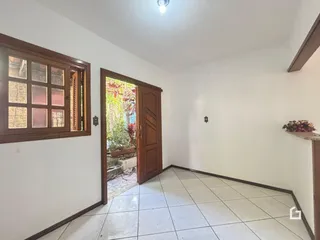 Vista interna de um ambiente com piso de cerâmica e molduras de madeira.
