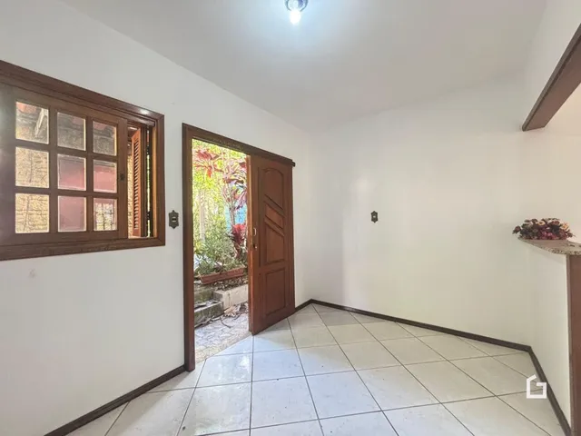 Vista interna de um ambiente com piso de cerâmica e molduras de madeira.