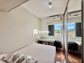 Quarto com cama de casal e janela com vista para a paisagem.