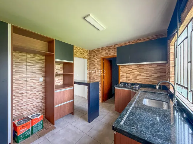 Vista interna de uma cozinha com armários de madeira e revestimento de parede em Lajeado.