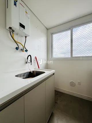 Vista da bancada da cozinha com pia e armários.