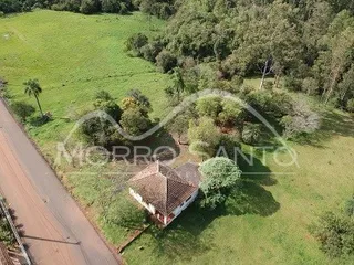 Vista aérea de uma área verde com vegetação e uma estrada rural.