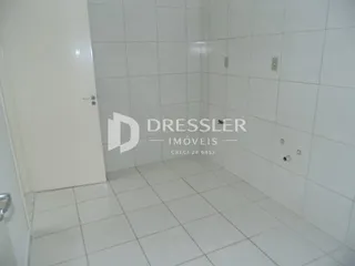 Corredor com paredes e piso de cerâmica brancos.
