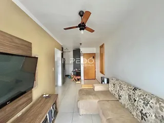 Sala de estar com sofá e televisão em um apartamento.