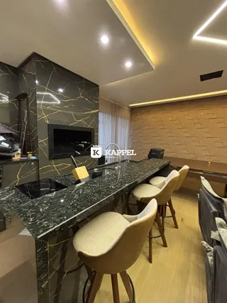 Foto de uma cozinha moderna com ilha escura e cadeiras de design.
