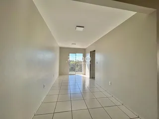 Corredor interno de uma residência com piso de cerâmica branca.