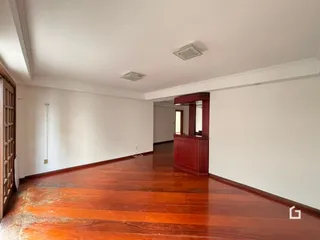 Interior de uma sala com piso de madeira polida.