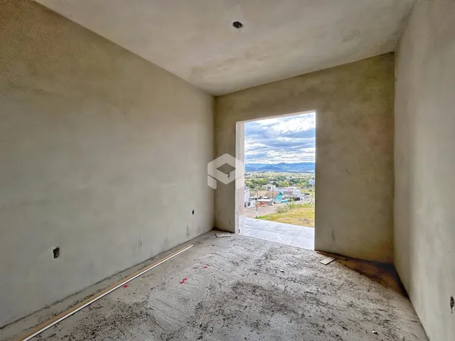 Foto de um cômodo vazio com paredes brancas e piso de concreto.