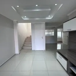 Foto de um corredor interno com paredes brancas e piso claro.