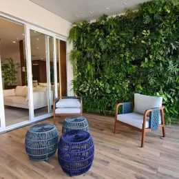 Foto de uma sala de estar com uma parede verde densa no fundo.