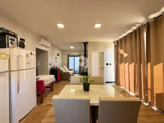 Sala de estar com piso de madeira e cortinas que cobrem a janela.