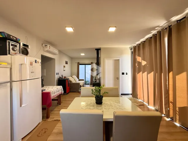 Sala de estar com piso de madeira e cortinas que cobrem a janela.