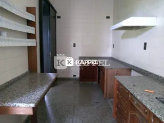 Foto de uma área de cozinha com bancadas e armários de madeira.