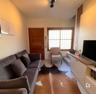 Sala de estar com sofá e janela de madeira.