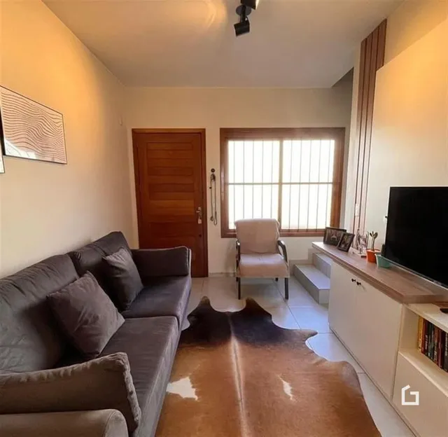 Sala de estar com sofá e janela de madeira.