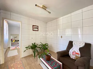 Sala de estar com paredes brancas e piso de cerâmica.