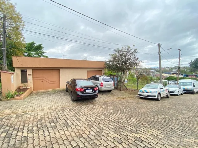 Fachada de uma residência em Lajeado, Brasil, com garagem e estacionamento pavimentado.