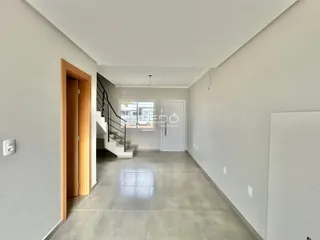 Hall de entrada com piso de cerâmica e escadaria.