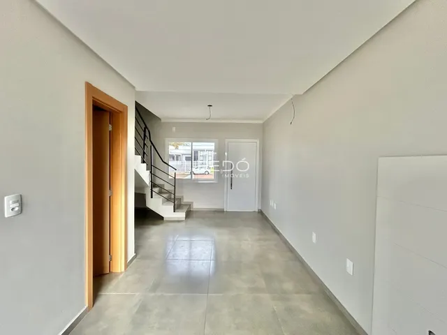 Hall de entrada com piso de cerâmica e escadaria.