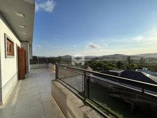 Vista da varanda com paisagem verde ao fundo.