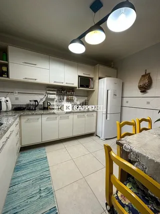 Esta é uma foto de uma cozinha com armários brancos e piso de cerâmica.