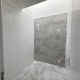 Parede revestida com azulejos brancos em um ambiente interno.