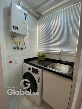 Interior de uma área de serviço com máquina de lavar e pia em um imóvel.
