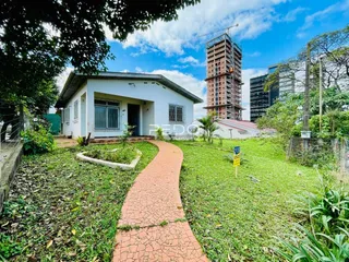 Vista externa de uma casa em Lajeado, Brasil, com jardim e construção ao fundo.