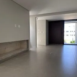 Vista interna de um espaço amplo com piso claro e paredes brancas.