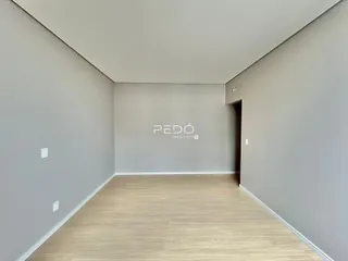 Interior de um cômodo com paredes cinzas e piso de madeira clara.