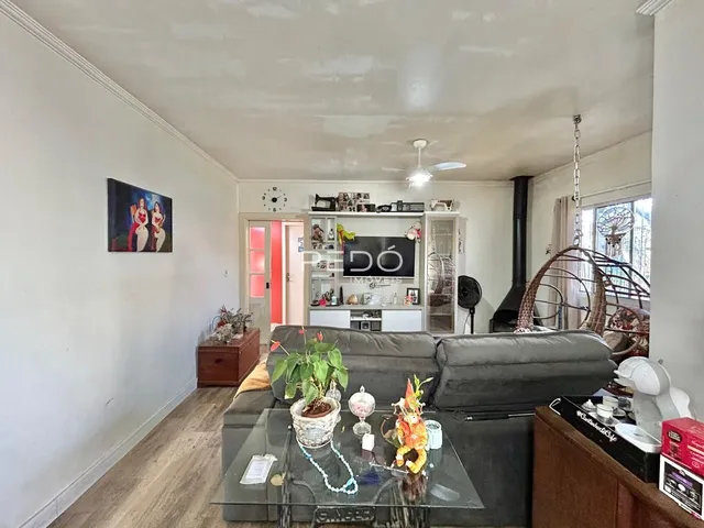 Sala de estar com sofá e piso de madeira em imóvel no Brasil.