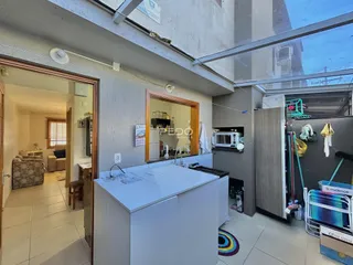 Vista interna de uma cozinha e área de passagem em um imóvel no Brasil.