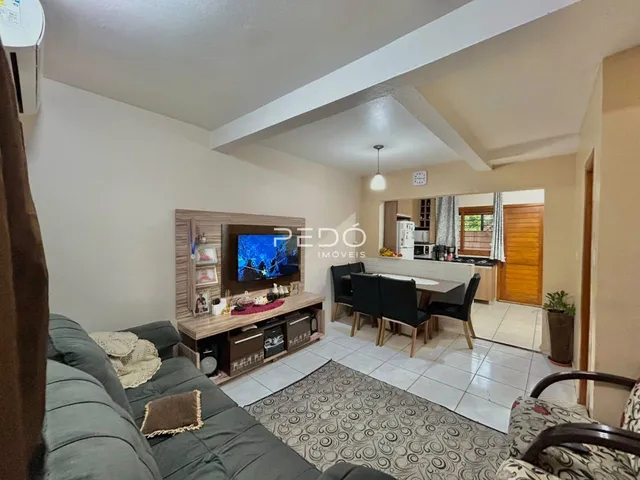 Sala de estar com sofá e área de jantar em um apartamento.