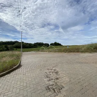 Vista externa da entrada pavimentada de uma propriedade em Lajeado, com área verde ao fundo.