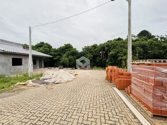 Vista externa de um terreno com tijolos e área pavimentada.
