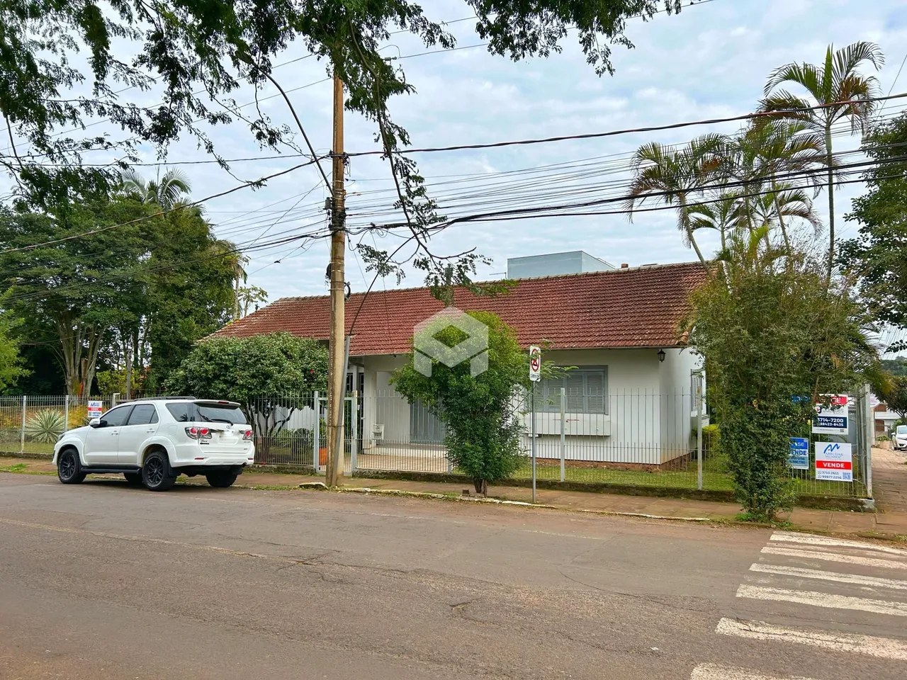 Fachada de uma residência em Lajeado, Brasil, com cerca e vegetação ao redor.