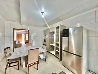 Interior de uma sala de jantar com cozinha moderna em um imóvel no Brasil.