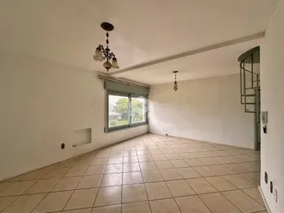 Sala ampla com piso de cerâmica clara e teto branco.