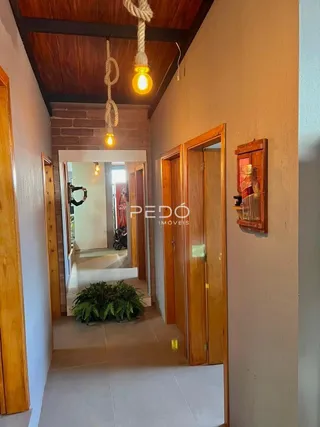 Hall de entrada com portas de madeira e parede de tijolos exposta.