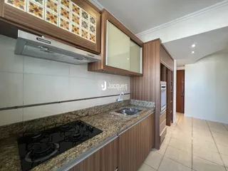Cozinha com armários de madeira e bancada de granito.